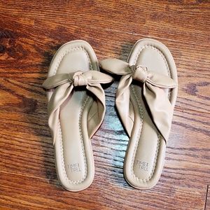 Nude flip flops with tie bow detail